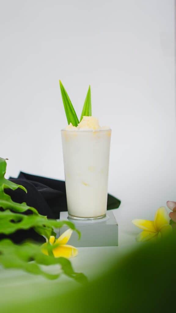 A refreshing pineapple coconut smoothie topped with a tropical garnish, perfect for a summer treat.