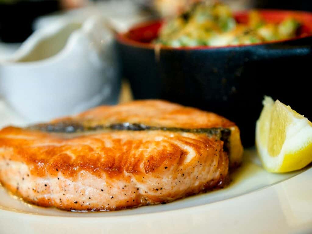 Delicious pan-seared salmon steak garnished with a lemon slice, showcasing a perfect dining experience.