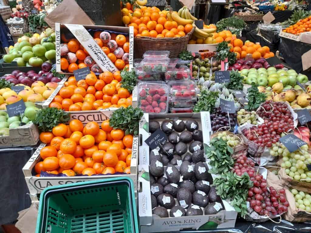 Vibrant display of fresh fruits and vegetables at a market stall in London.