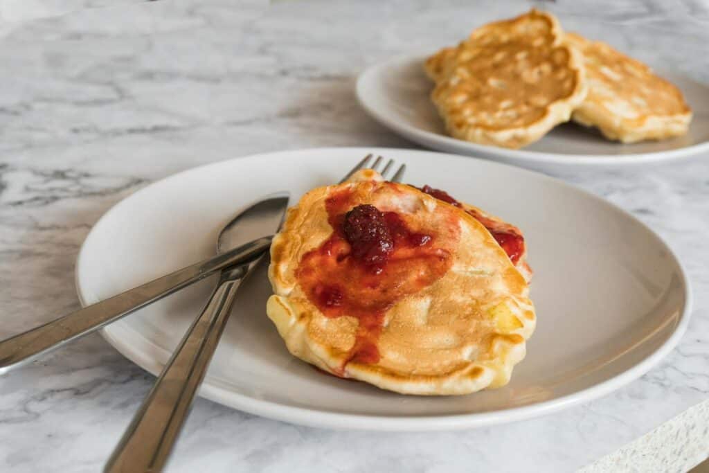 A mouthwatering close-up of raspberry-topped pancakes on a stylish plate ready to enjoy.