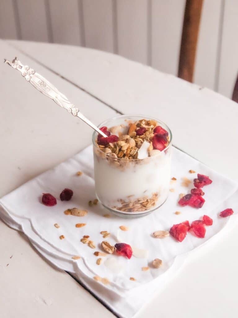 white and brown ceramic cup with stainless steel spoon on white ceramic round plate